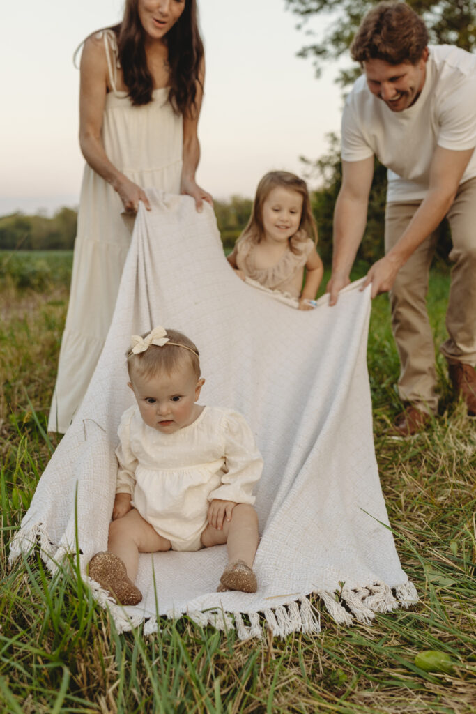 Lifestyle family photography session with playful children in a grassy field in Indiana 