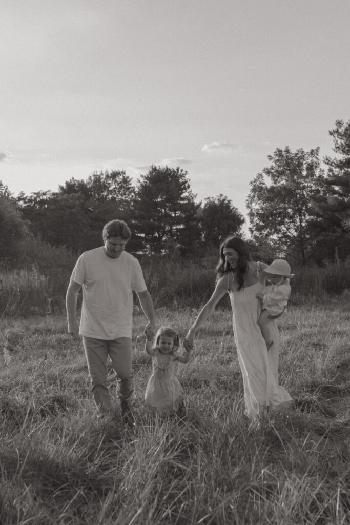 Family of four walking hand in hand in Trafalgar, Indiana. 