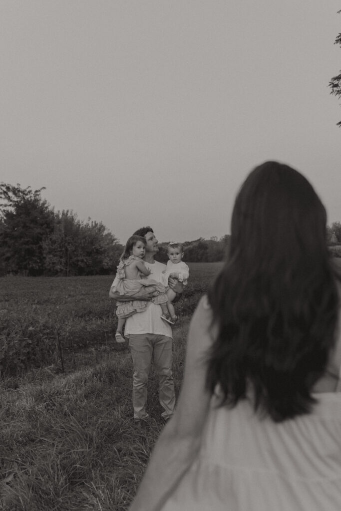 Lifestyle family photography session with playful children in a grassy field in Indiana 