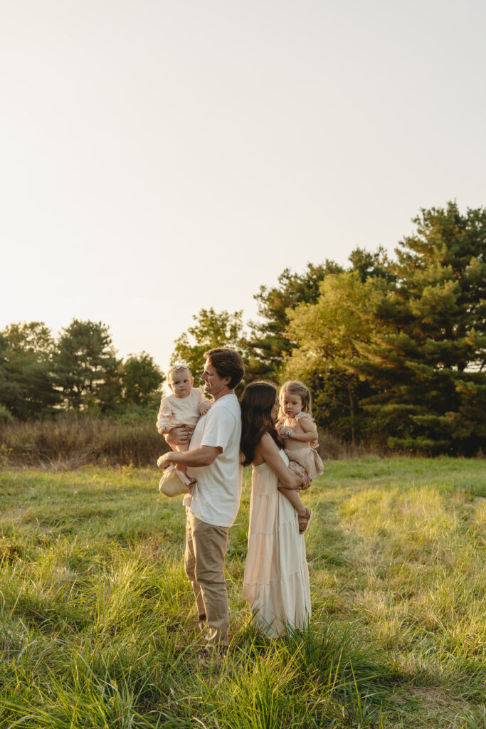 Lifestyle family photography session with playful children in a grassy field in Indiana 