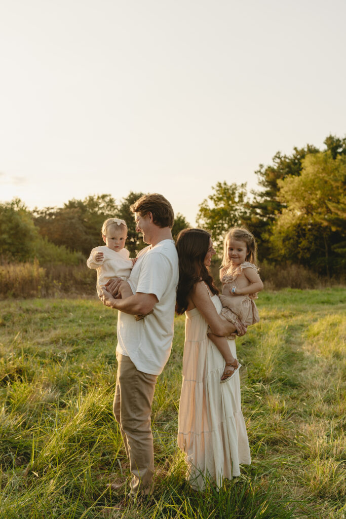Lifestyle family photography session with playful children in a grassy field in Indiana 